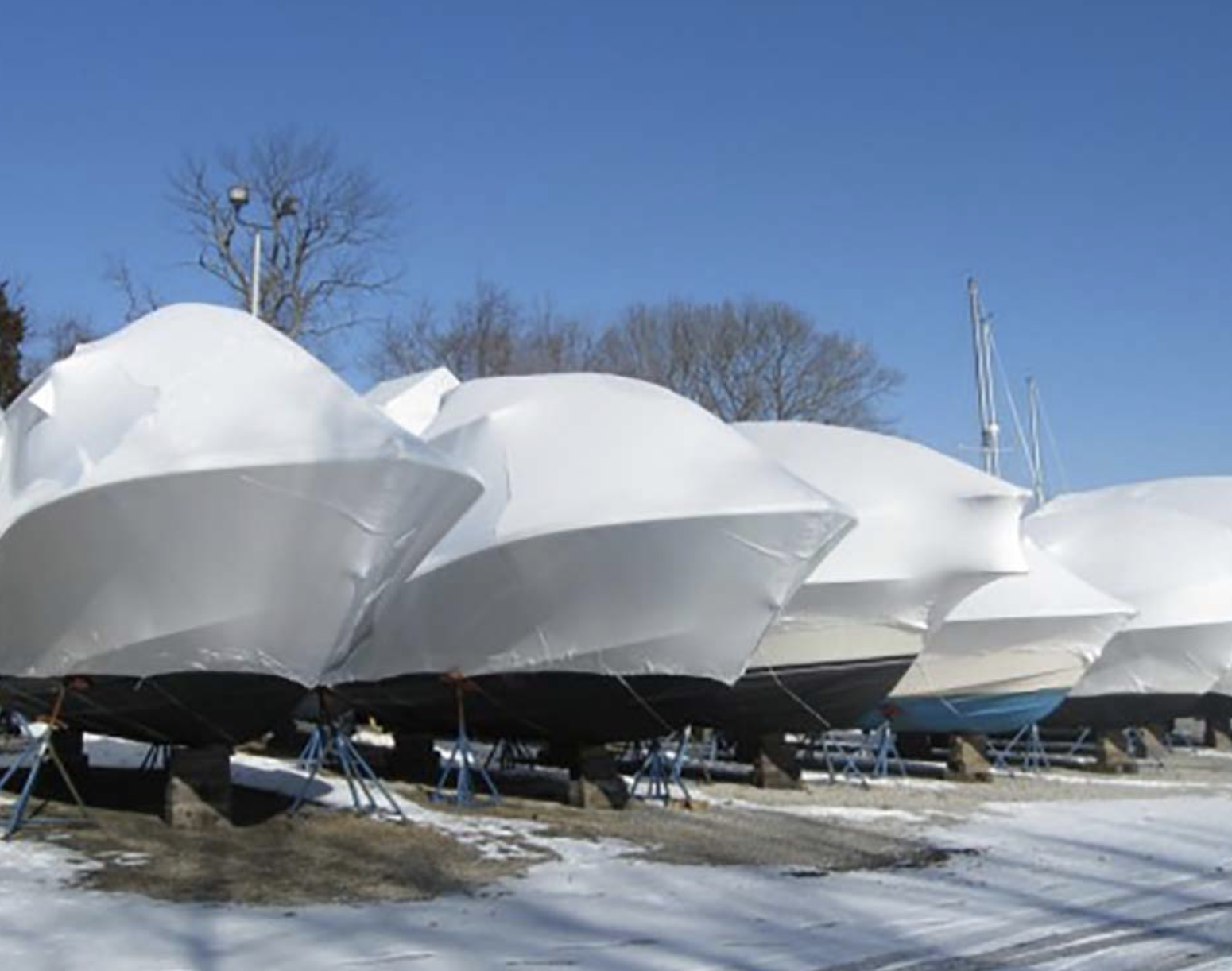 Covered boats in winter storage at a dealer lot